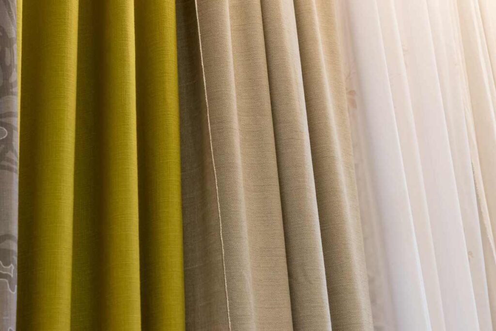 Several different kinds of drapery fabric hanging side by side