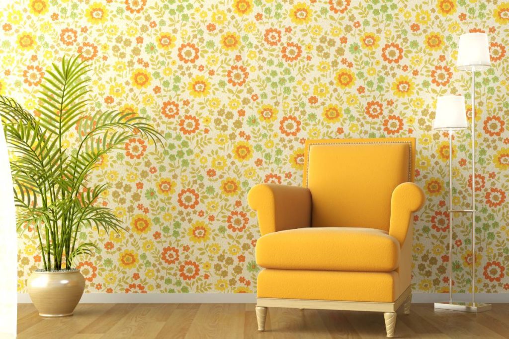 Bright yellow, orange, and green floral wallpaper with a sunny yellow armchair and houseplant near Lancaster, PA