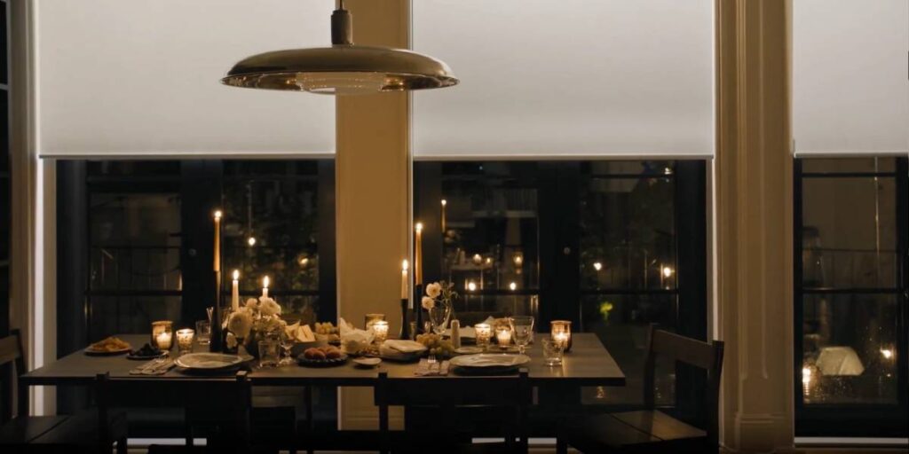 A candlelit dinner with Hunter Douglas Aura® Illuminated Shades on large windows as the backdrop near Lancaster, PA